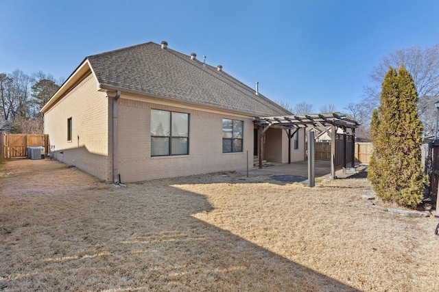 rear view of property featuring central AC unit, a patio area, and a pergola