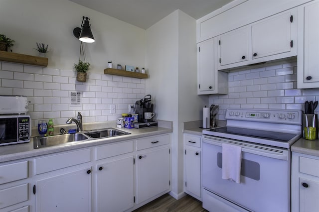 kitchen featuring tasteful backsplash, white cabinetry, sink, and electric stove