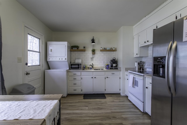 kitchen featuring white range with electric cooktop, stacked washer and dryer, white cabinetry, and stainless steel refrigerator with ice dispenser