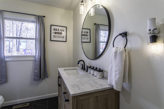 bathroom with tile patterned flooring, vanity, and toilet