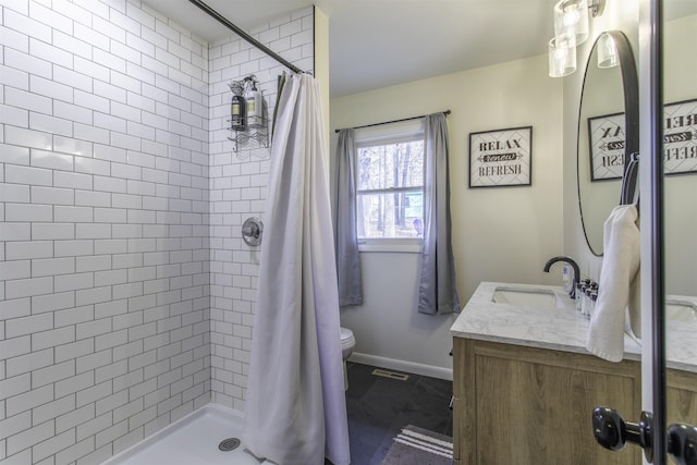 bathroom with walk in shower, vanity, and toilet