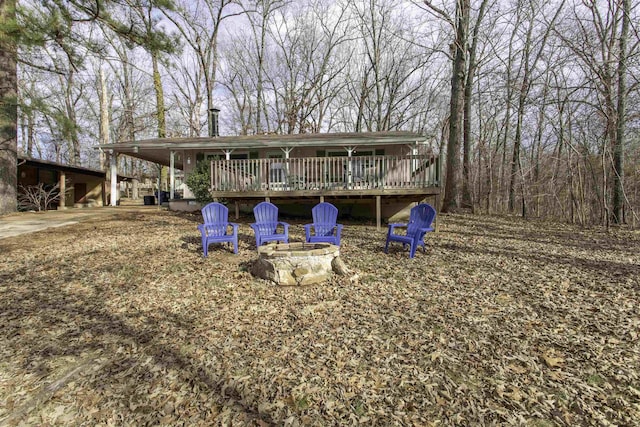 rear view of property featuring a deck and an outdoor fire pit