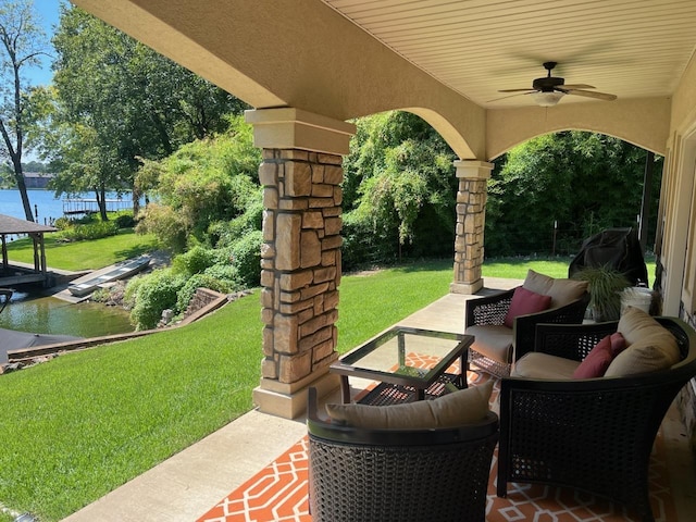 view of patio / terrace featuring a water view and ceiling fan