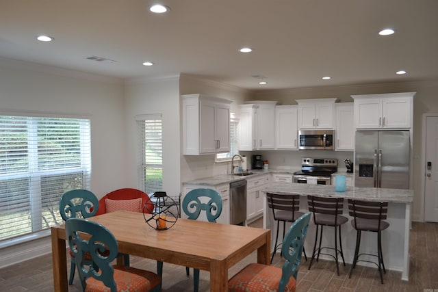 kitchen featuring a kitchen island, white cabinets, and appliances with stainless steel finishes