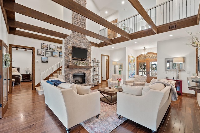 living room with dark hardwood / wood-style flooring, a fireplace, french doors, and beamed ceiling