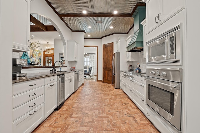 kitchen featuring crown molding, stainless steel appliances, sink, and white cabinets