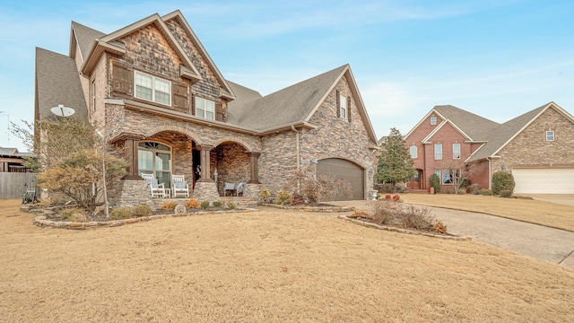 view of front of house featuring a garage, a front yard, and covered porch