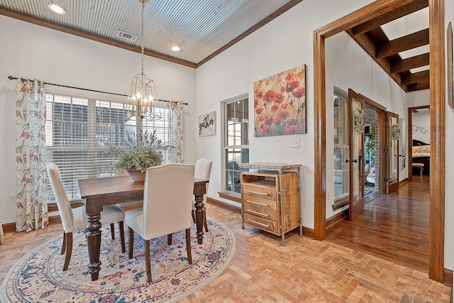 dining area featuring ornamental molding, french doors, a chandelier, and a high ceiling