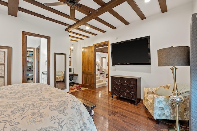 bedroom featuring ceiling fan, ensuite bath, wood-type flooring, and beamed ceiling