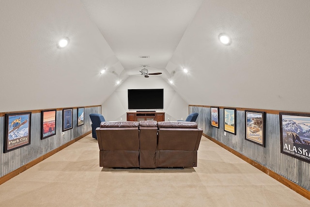 home theater with ceiling fan, lofted ceiling, wooden walls, and light carpet