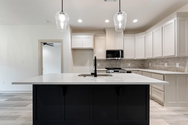 kitchen with pendant lighting, sink, and a center island with sink