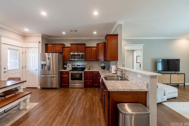 kitchen featuring sink, dark wood-type flooring, appliances with stainless steel finishes, ornamental molding, and kitchen peninsula