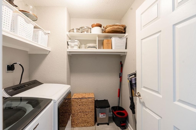 laundry area featuring light tile patterned floors, independent washer and dryer, and a textured ceiling