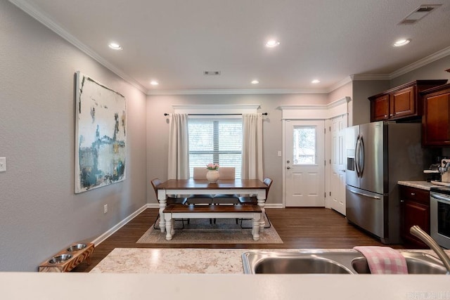 kitchen featuring crown molding, appliances with stainless steel finishes, and dark hardwood / wood-style floors