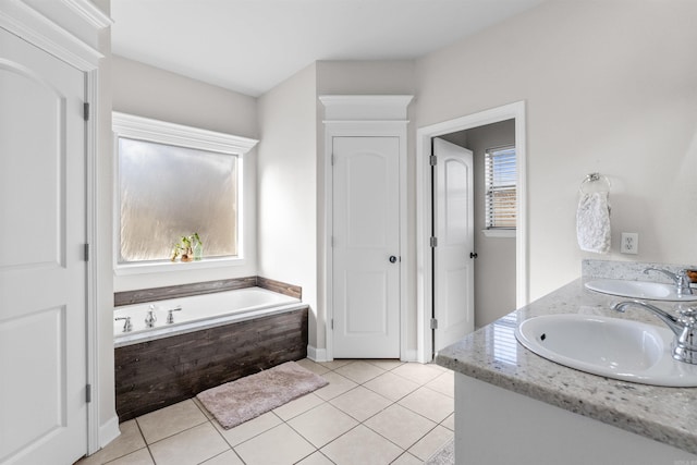 bathroom featuring tile patterned flooring, tiled tub, and a wealth of natural light