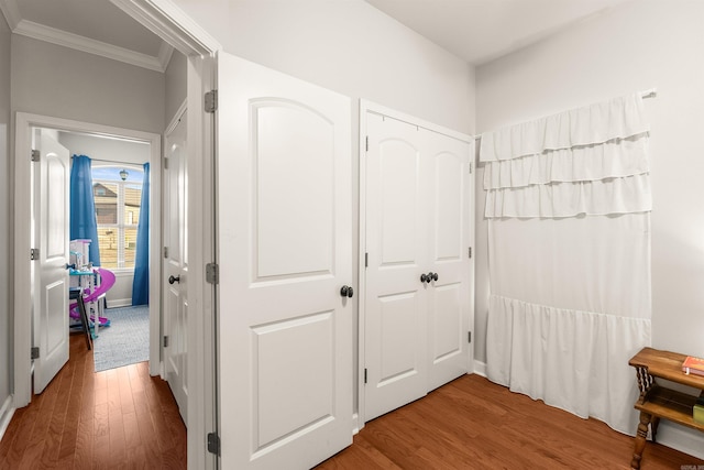 hall with ornamental molding and hardwood / wood-style floors