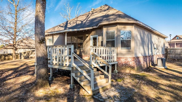 rear view of house with central AC and a deck