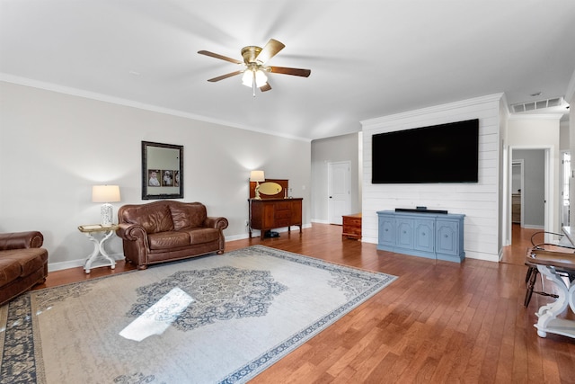 living room featuring hardwood / wood-style floors, ornamental molding, and ceiling fan