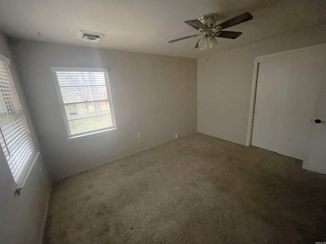 unfurnished room with ceiling fan and carpet