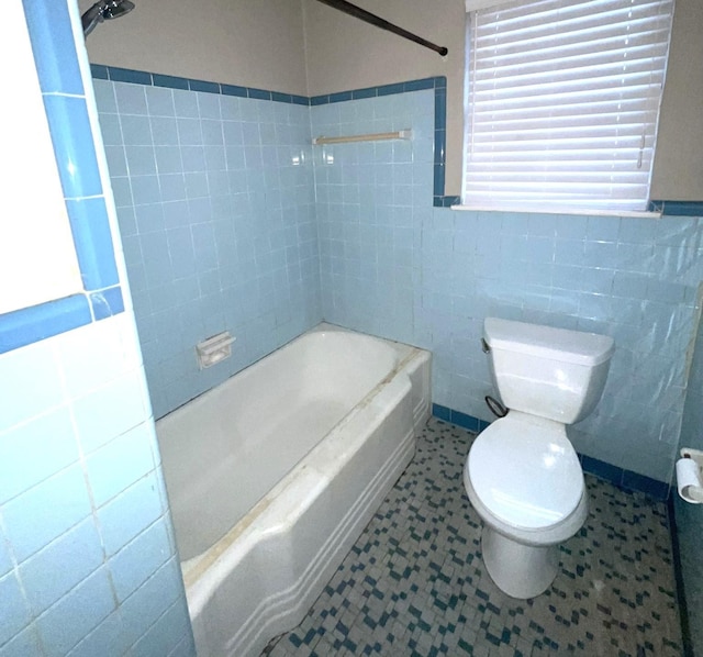 bathroom with tile walls and toilet