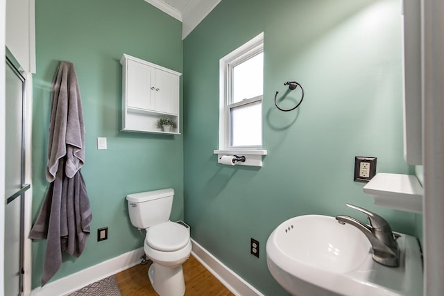 bathroom featuring sink, wood-type flooring, ornamental molding, and toilet