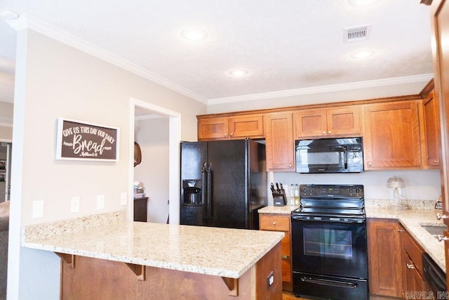 kitchen featuring light stone countertops, black appliances, a breakfast bar, and kitchen peninsula