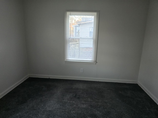 unfurnished room with dark carpet