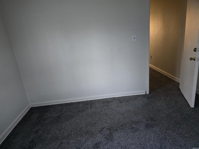 spare room with dark carpet