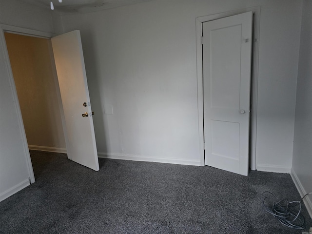 spare room featuring dark carpet