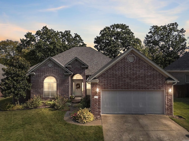 view of front of home with a yard and a garage