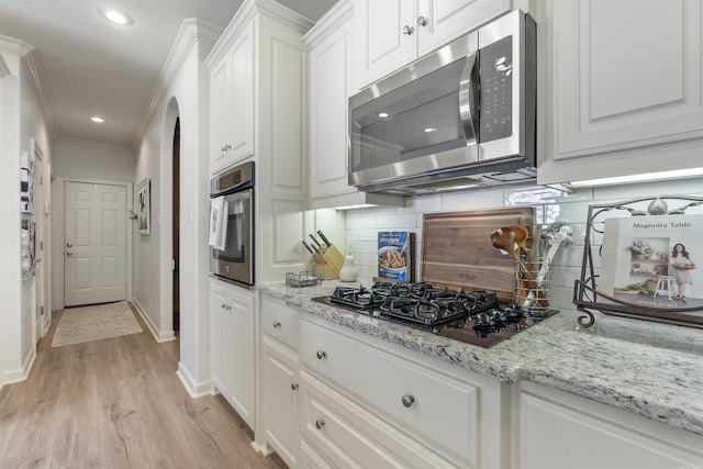 kitchen featuring stainless steel appliances, light stone countertops, light hardwood / wood-style flooring, and white cabinets