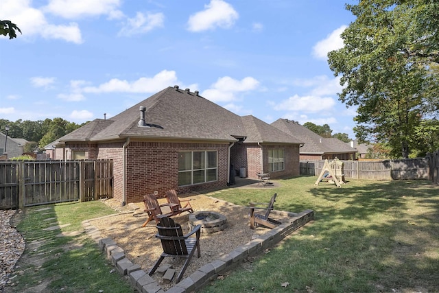 rear view of property featuring a yard, a playground, and a fire pit