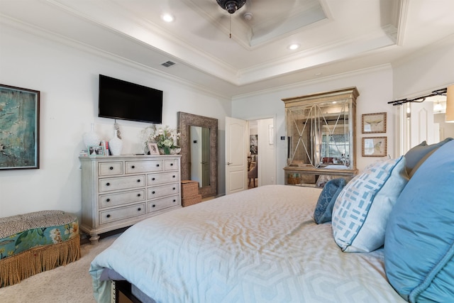 bedroom featuring crown molding, a tray ceiling, ceiling fan, and carpet flooring