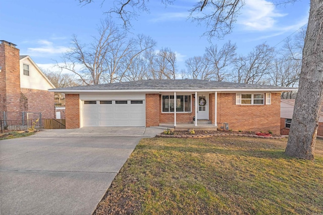 ranch-style home featuring a garage, covered porch, and a front yard