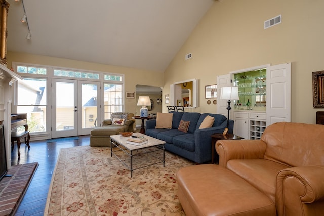 living room featuring french doors, track lighting, high vaulted ceiling, and hardwood / wood-style floors