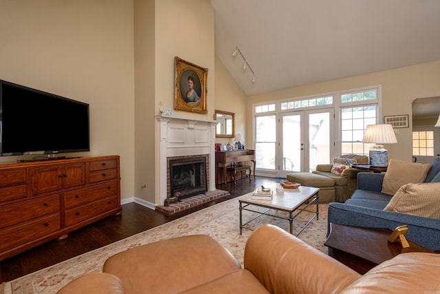 living room with dark hardwood / wood-style floors, a fireplace, high vaulted ceiling, and french doors