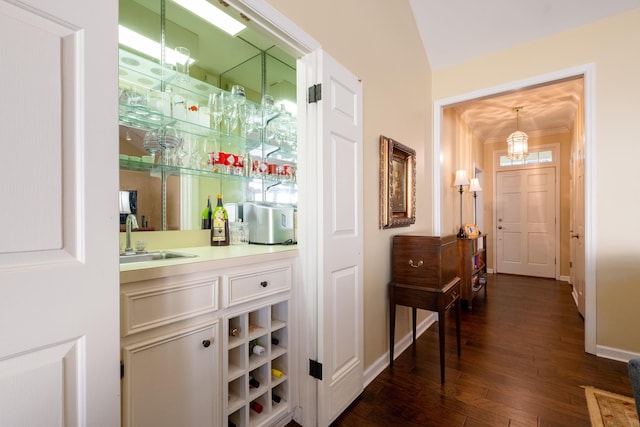 bar with dark hardwood / wood-style floors, decorative light fixtures, and sink