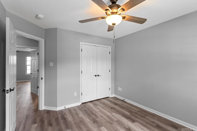 unfurnished bedroom featuring ceiling fan, hardwood / wood-style floors, and a closet