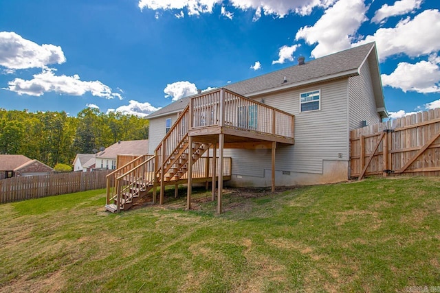 back of property with a wooden deck and a lawn