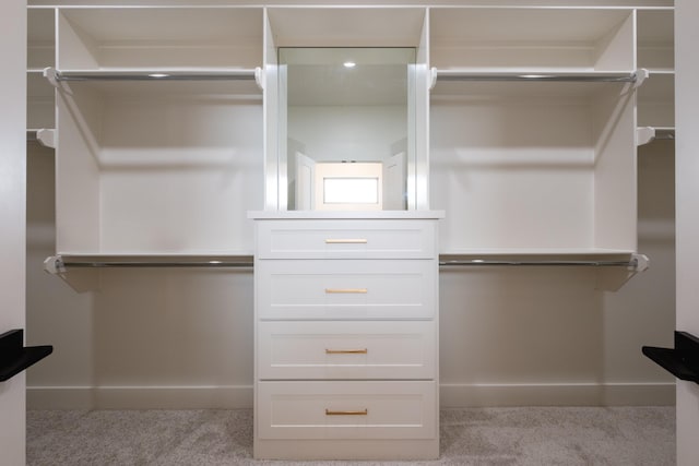 walk in closet featuring light colored carpet