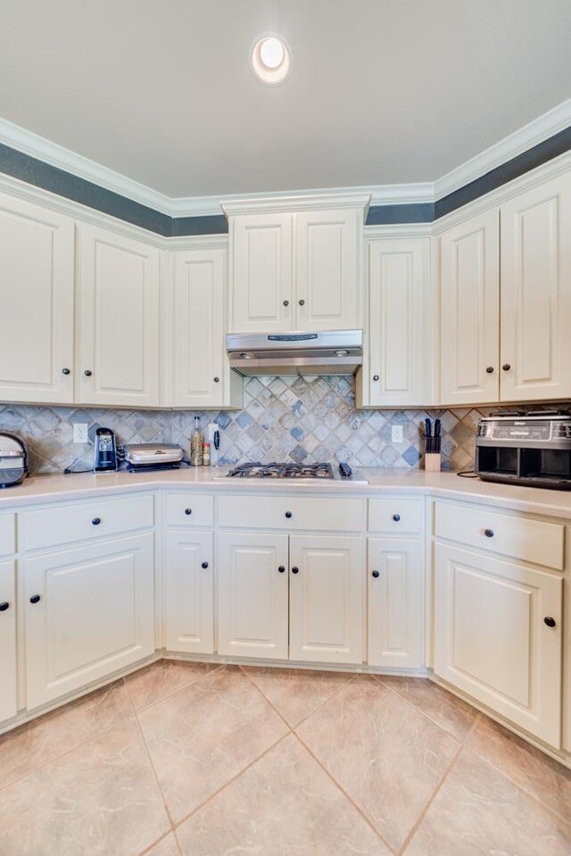 kitchen with white cabinetry, ornamental molding, stainless steel gas cooktop, and tasteful backsplash