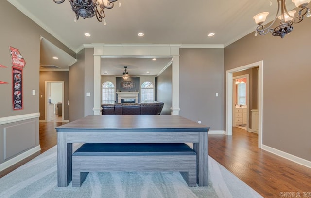 dining room featuring hardwood / wood-style flooring, ornamental molding, and a notable chandelier