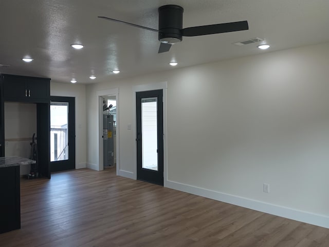 spare room with a textured ceiling, dark wood-type flooring, and ceiling fan