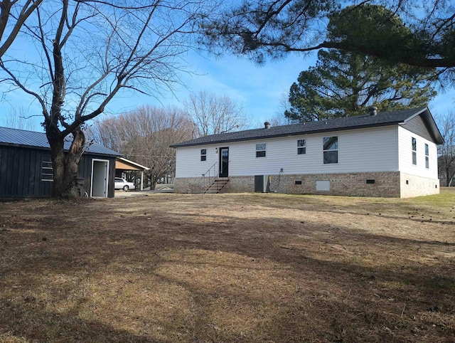 back of house featuring a carport, a yard, and central AC unit