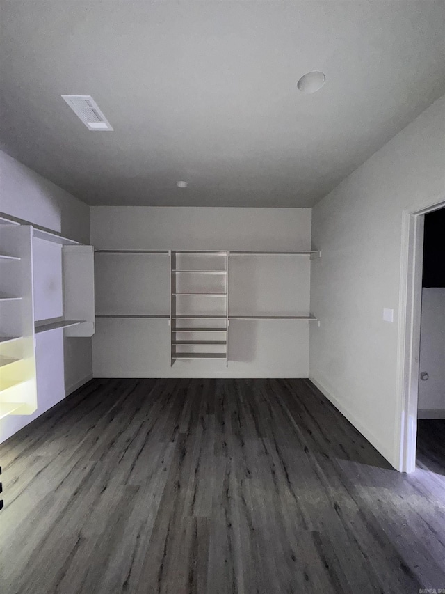 empty room with dark wood-type flooring and visible vents