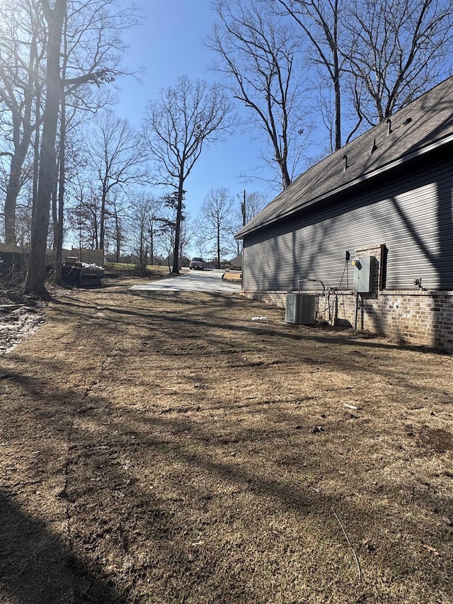 view of side of home featuring a lawn and central air condition unit