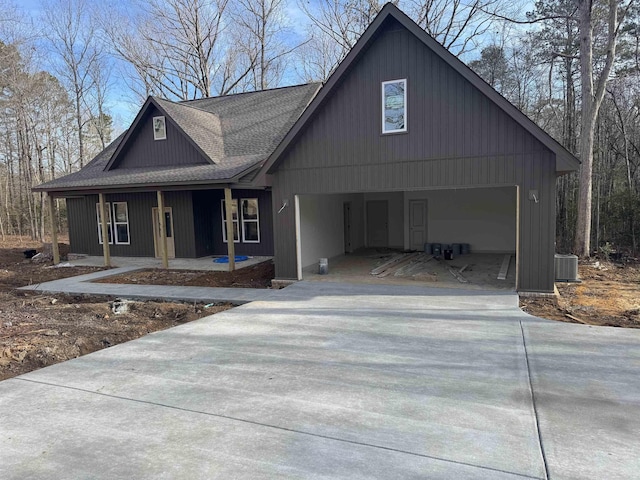 view of front facade featuring a porch, a garage, and central air condition unit