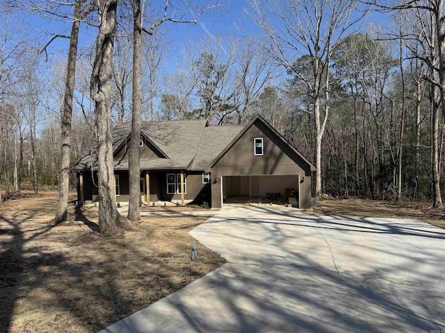 view of front of property featuring a garage, driveway, and a shingled roof