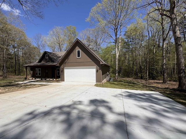 5389 Pear Orchard Dr, Little Rock, AR 72206 - view of property exterior with an attached garage, a wooded view, and concrete driveway