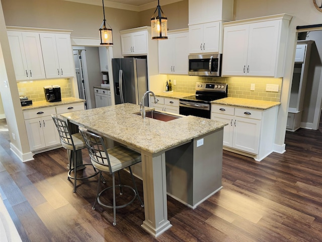 kitchen with sink, white cabinetry, decorative light fixtures, a center island with sink, and appliances with stainless steel finishes